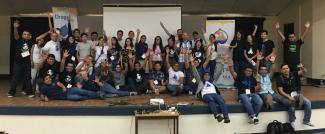 DrupalCamp Nicaragua attendees raising their hands in unison.